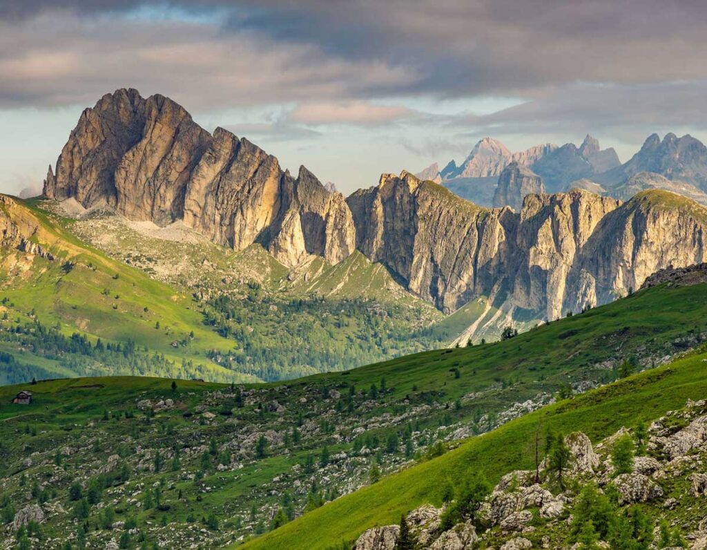 jagged mountain with some green foliage and grey clouds
