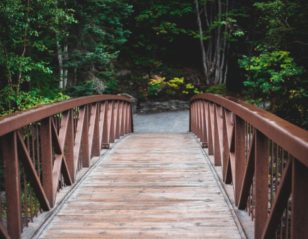 pov walking over wood slat bridge
